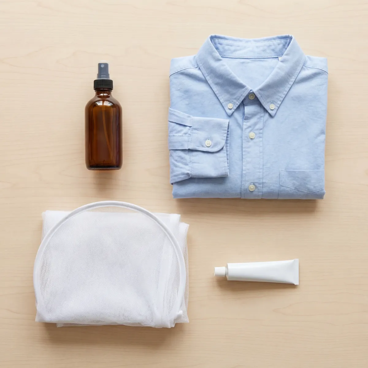 Flat lay of mosquito prevention items including insect repellent, long-sleeved clothing, and a bed net